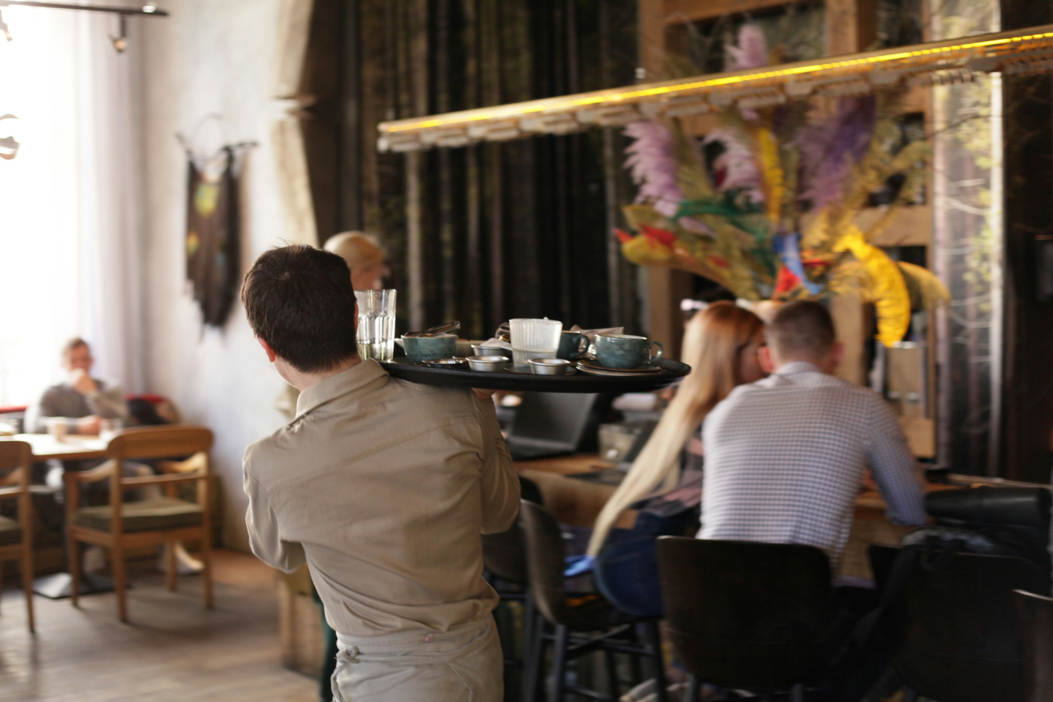Server carrying dishes through a restaurant
